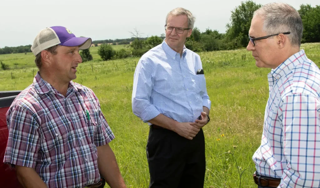 Scott Pruitt (far right) talks with a Kansas farmer in June