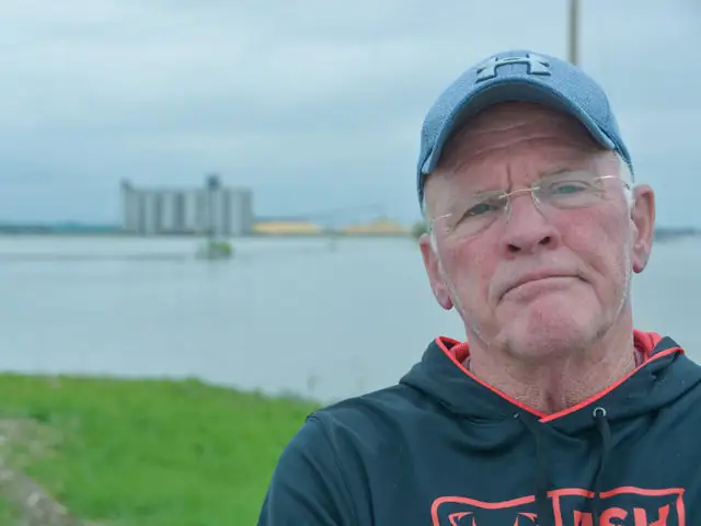 Richard Oswald stands near his still-flooded farm by Rockport