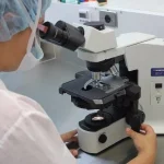 Scientist with microscope generic
